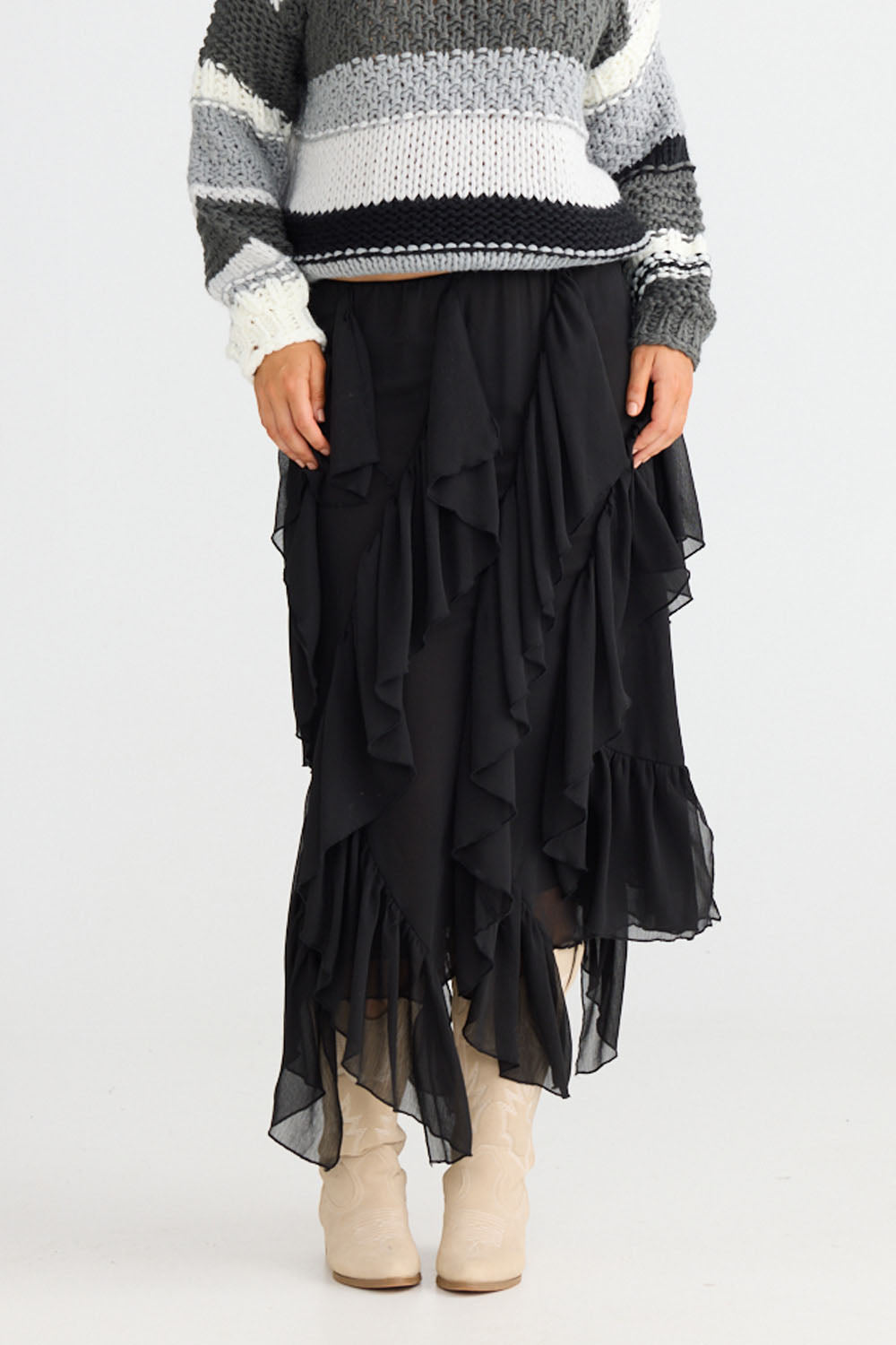 Model wearing Rafael Skirt in black with elasticated waist, side view on white background