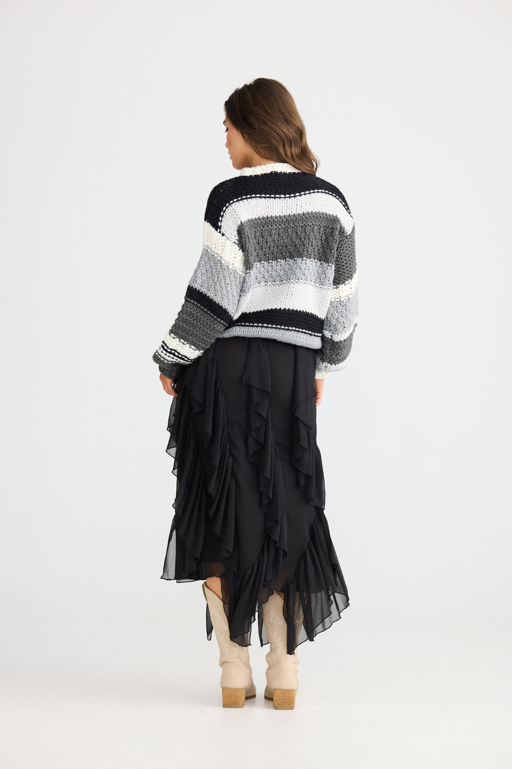 Model wearing Rafael Skirt in black with elasticated waist, back view on white background