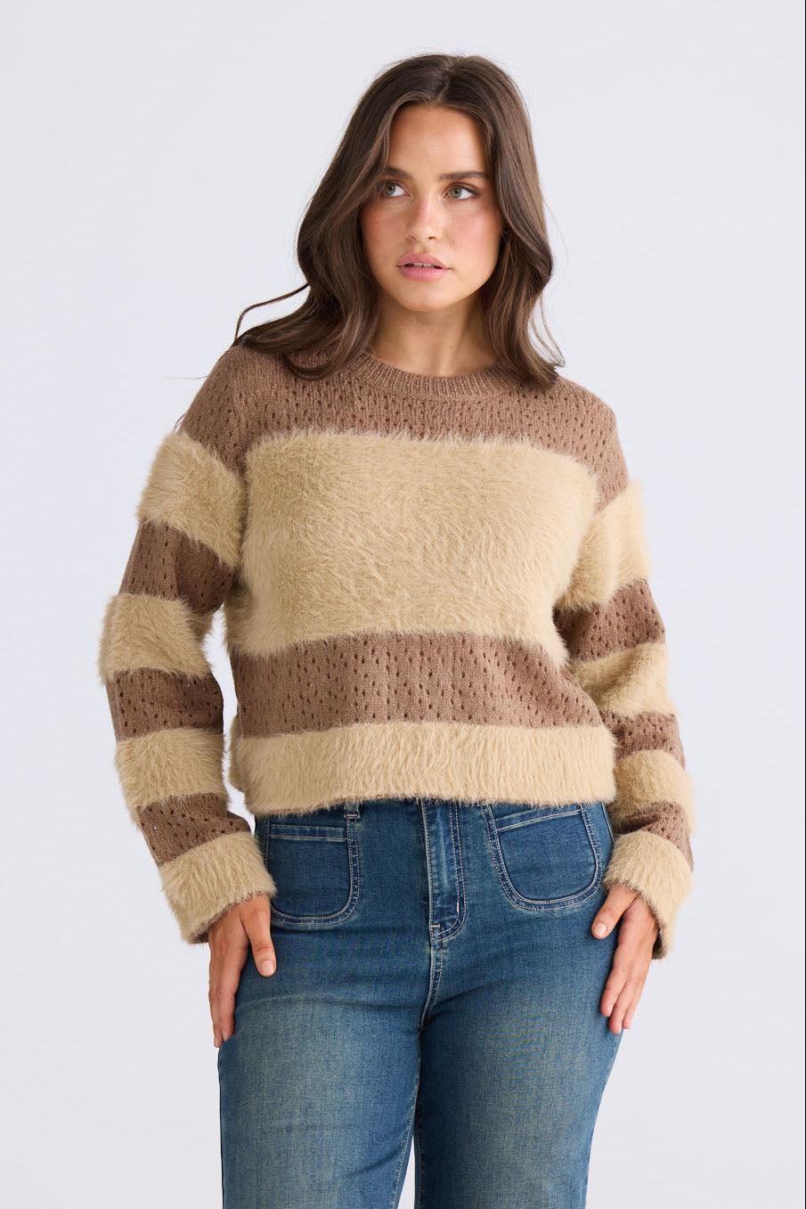 Model wearing Kyoko Knit in mocha and taupe with ribbed neckline and long sleeves, front view on white background