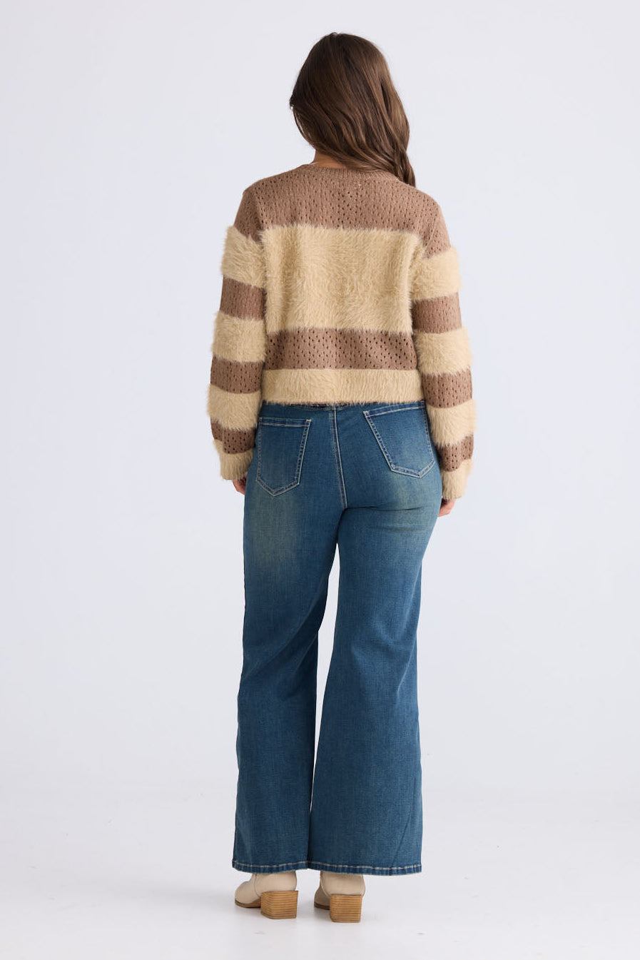 Model wearing Kyoko Knit in mocha and taupe with ribbed neckline and long sleeves, back view on white background