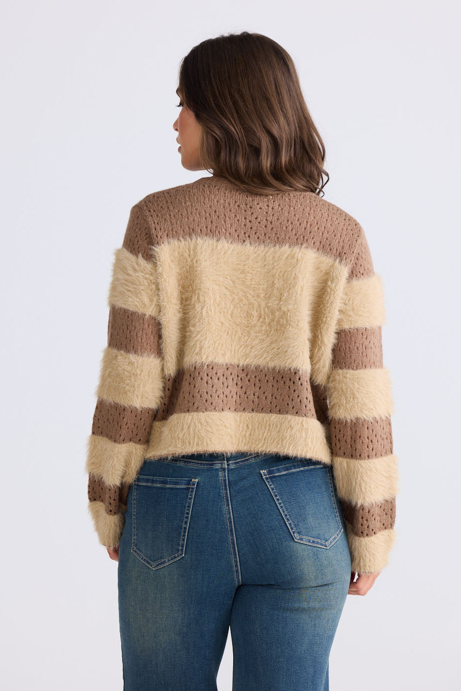 Model wearing Kyoko Knit in mocha and taupe with ribbed neckline and long sleeves, side view on white background
