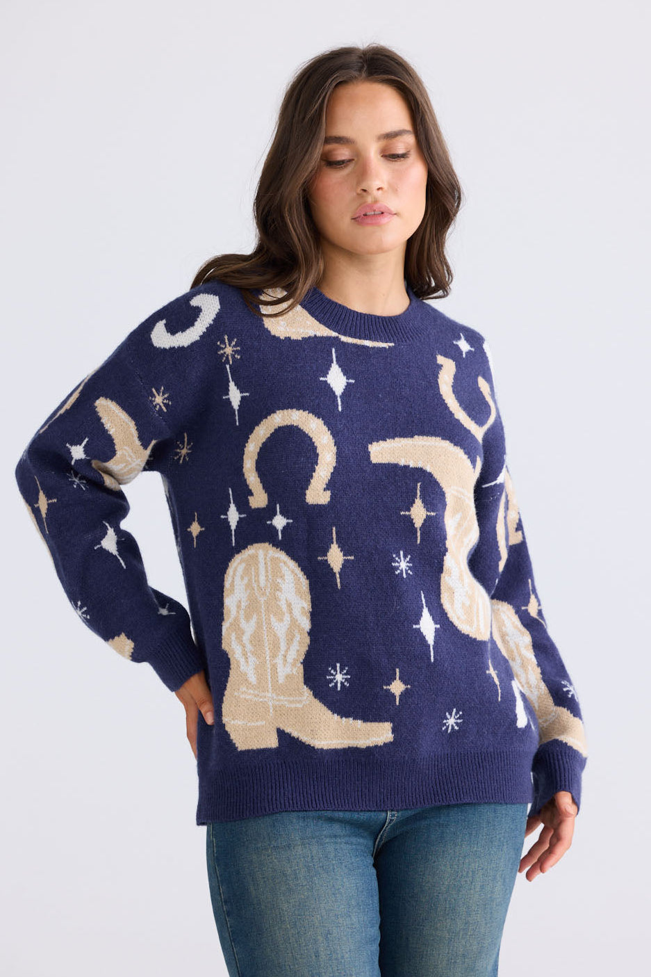 Model wearing Lucky Boots Knit in navy with ribbed neckline and cowboy-themed print, back view on white background
