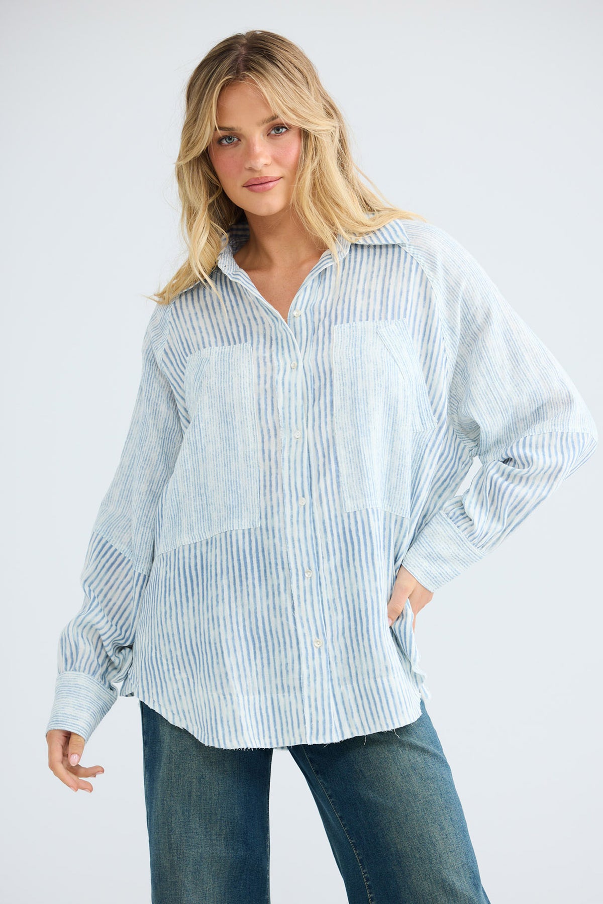 Model wearing Bodhi Shirt in blue stripe, front view.
