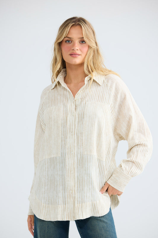 Model wearing Bodhi Shirt in natural stripe, front view.