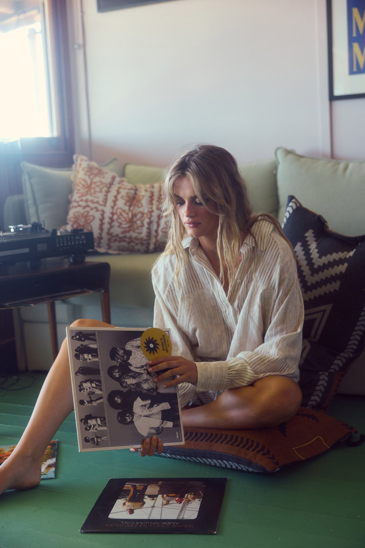 Bodhi Shirt in natural stripe, relaxed at home flicking through a record.