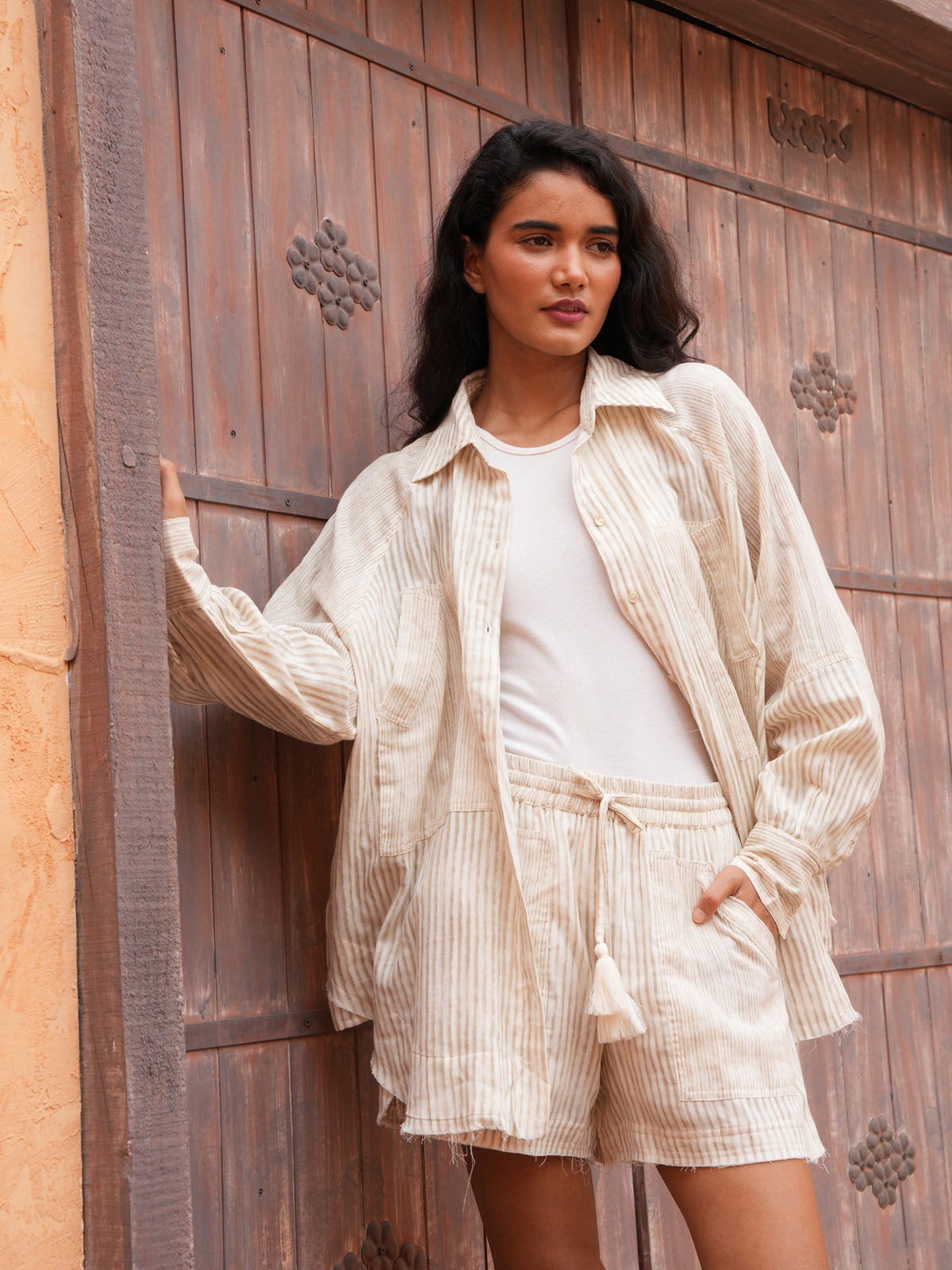 Bodhi Shirt in natural stripe worn open over a white tank with the matching Bodhi Short.