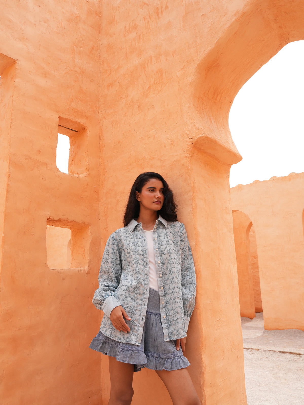 Flower Child Shirt in powder blue with the Ithika Short, full length in a terracotta archway.
