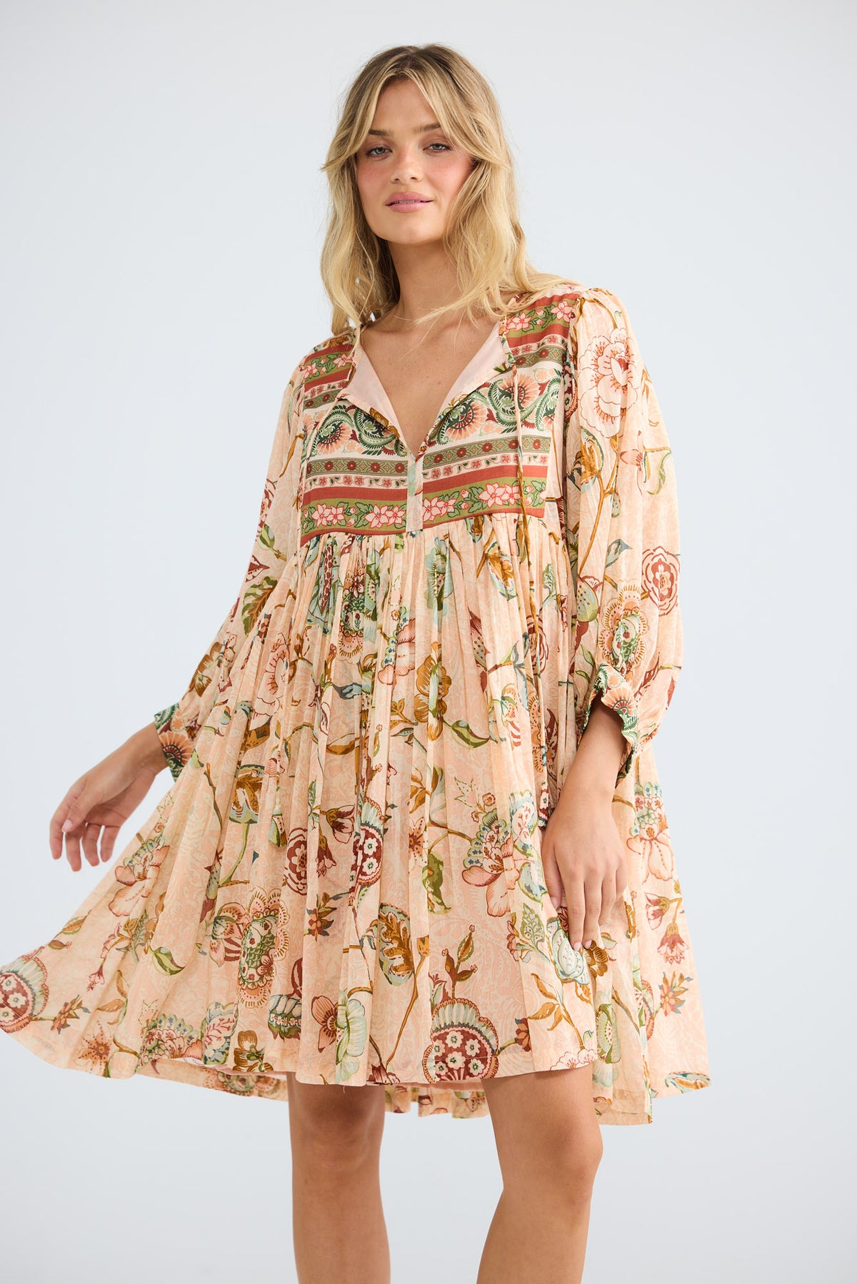 Model wearing Wisteria Mini Dress in wildflower oasis, front view.