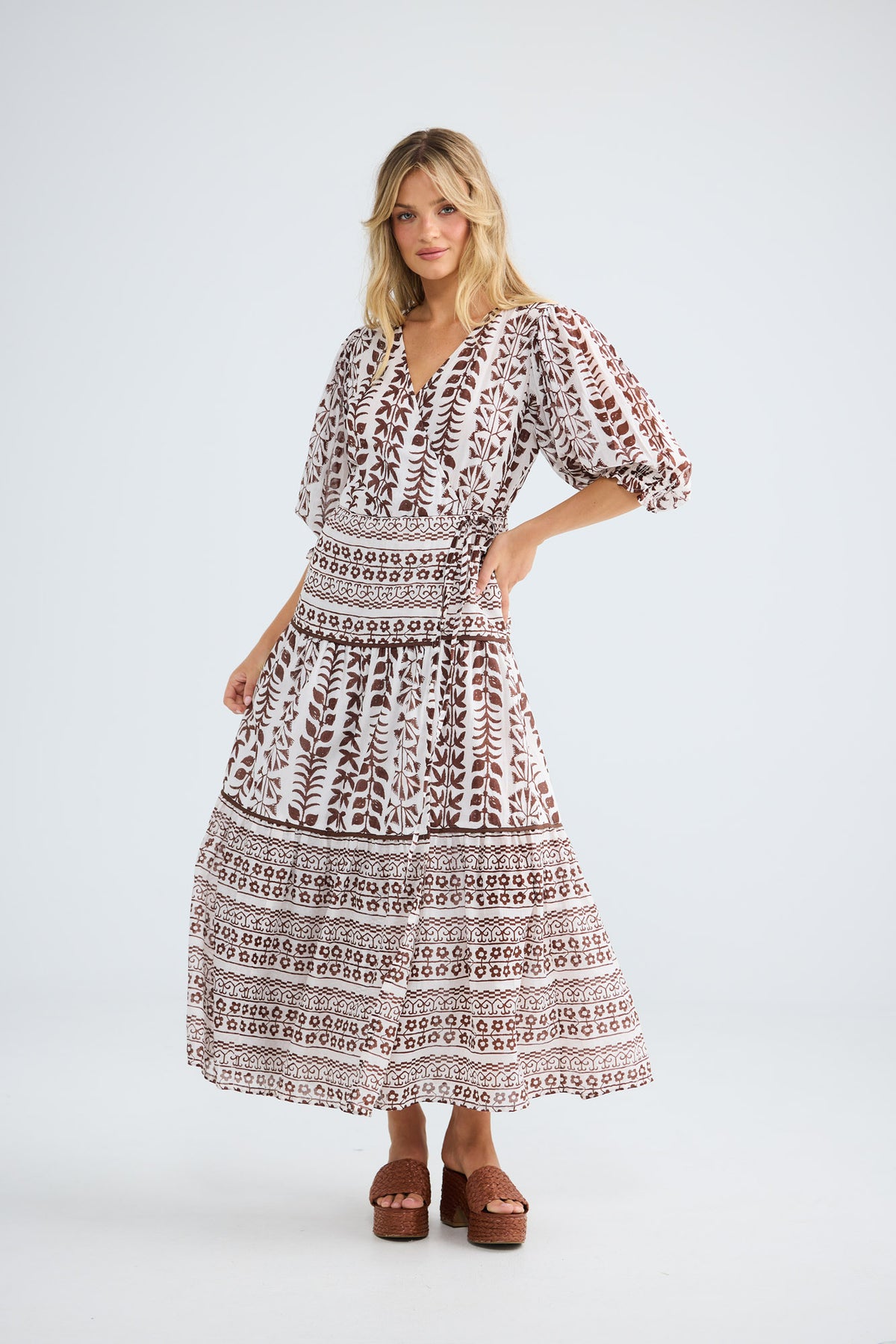 Model wearing Tara Wrap Dress in chocolate paro, front view.