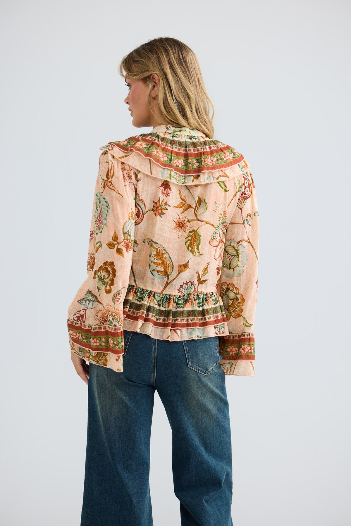 Model wearing Carmen Frill Top in wildflower oasis, front view.