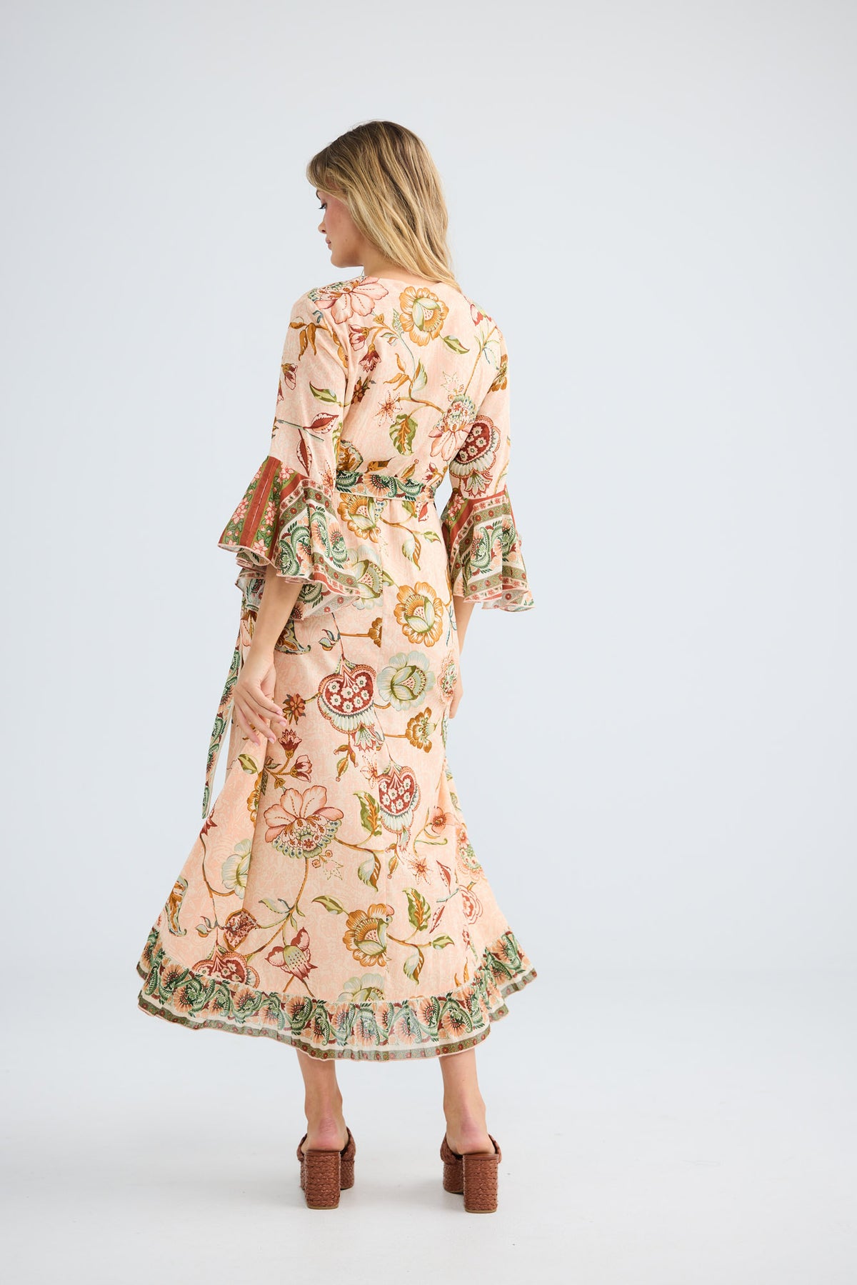 Model wearing Carly Wrap Dress in wildflower oasis, front view.