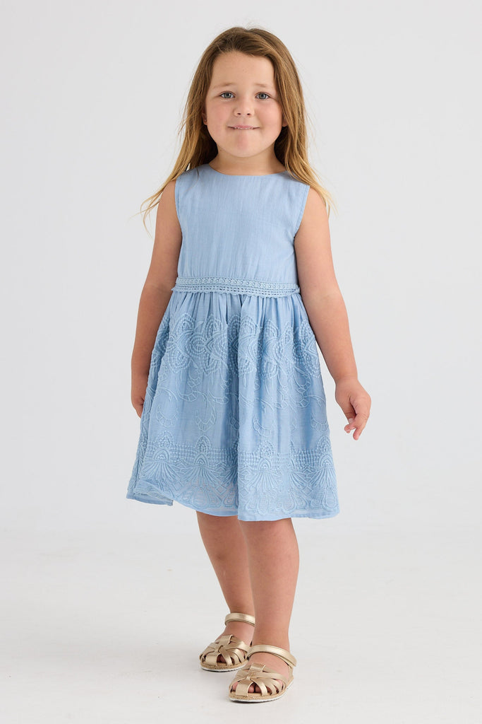 Young girl wearing a light blue dress on a white background