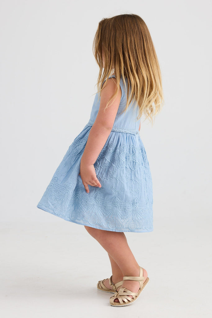 Young girl wearing a light blue dress on a white background