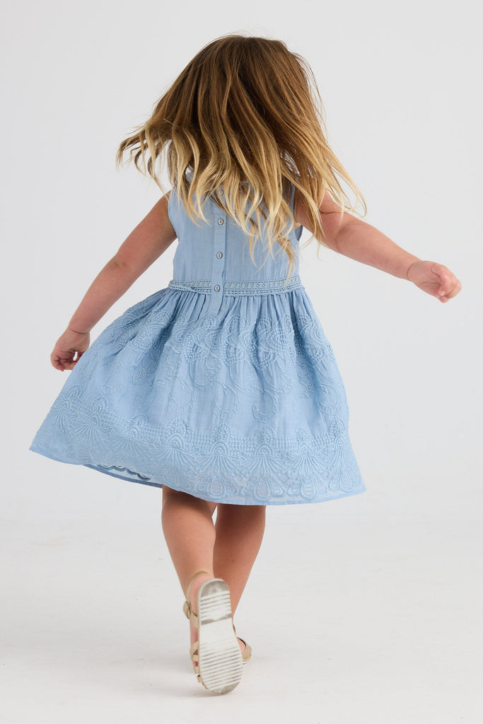 Child wearing a blue dress on a white background