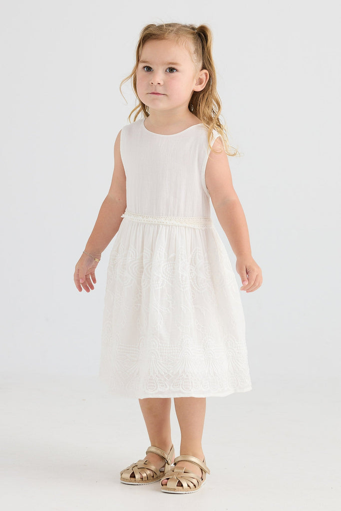 Young girl wearing a white dress on a plain background