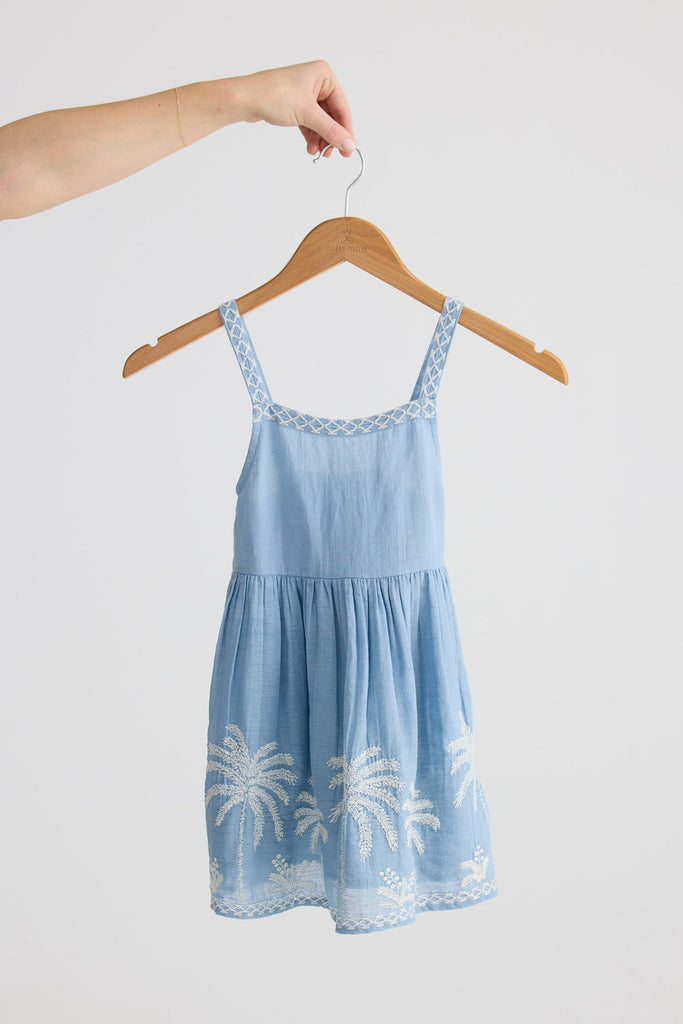 Light blue dress with white palm tree designs on a hanger against a white background